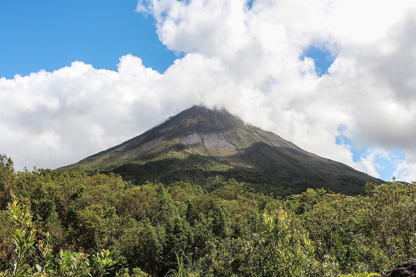 Cone of Arenal Volcano rising above green rainforest in Costa Rica